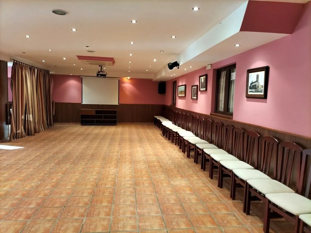 Salón de eventos del hotel con sillas alineadas, pantalla y proyector